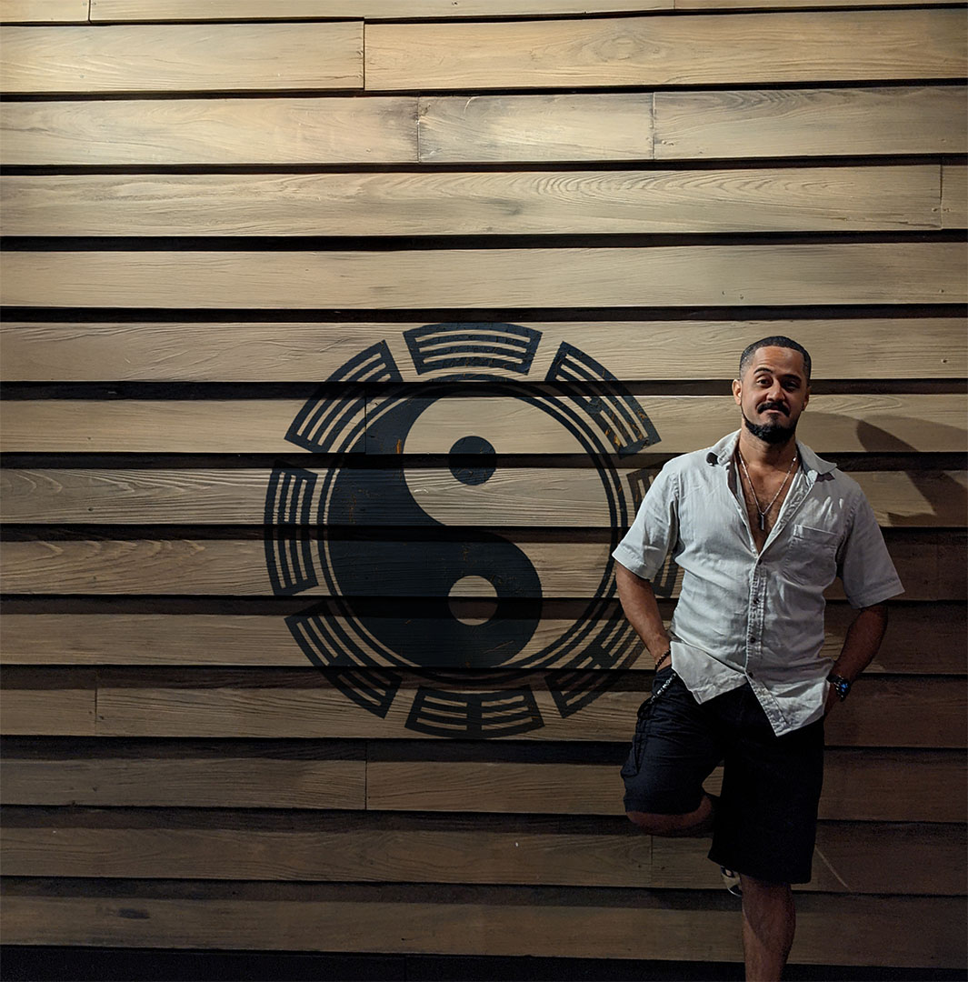 Sensei Stan beside the Naked Dojo symbol